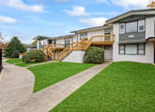Thumbnail 2 of 10 - the front of a house with a yard and a staircase