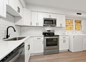 Thumbnail 10 of 10 - a kitchen with white cabinets and stainless steel appliances