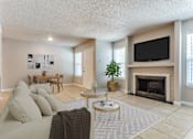 Thumbnail 1 of 11 - A living room with a couch, coffee table, and fireplace.