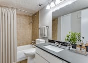 Thumbnail 6 of 11 - A bathroom with a toilet, sink, and shower.