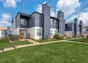 Thumbnail 17 of 19 - a row of townhomes with blue roofs and green grass