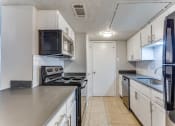 Thumbnail 2 of 19 - an empty kitchen with white cabinets and stainless steel appliances