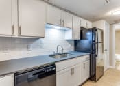 Thumbnail 11 of 19 - a kitchen with white cabinets and a sink and a refrigerator