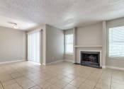 Thumbnail 4 of 19 - an empty living room with a fireplace and tiled floors