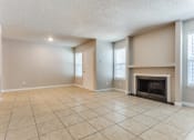 Thumbnail 5 of 19 - an empty living room with a fireplace and tile flooring