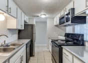 Thumbnail 8 of 19 - a kitchen with white cabinets and stainless steel appliances and a sink