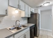 Thumbnail 10 of 19 - an empty kitchen with a sink and a refrigerator