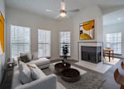 Thumbnail 6 of 24 - a living room with a couch and a table and a fireplace