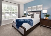 Thumbnail 10 of 25 - A bedroom with a large bed and a window with blinds.