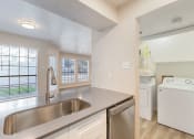 Thumbnail 1 of 28 - a kitchen with a sink and a washer and dryer