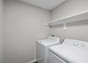 Thumbnail 46 of 54 - A white washing machine and dryer in a laundry room.