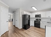 Thumbnail 48 of 54 - A kitchen with black appliances and white cabinets.