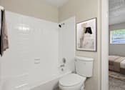 Thumbnail 9 of 22 - A white bathroom with a toilet, sink, and shower.