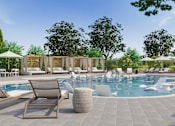 Thumbnail 36 of 37 - A large outdoor swimming pool surrounded by lounge chairs and umbrellas.