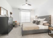 Thumbnail 17 of 35 - a bedroom with a bed and a dresser and a ceiling fan