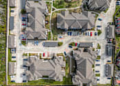 Thumbnail 23 of 28 - A bird's eye view of a residential area with houses and cars.
