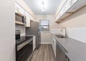Thumbnail 2 of 17 - a kitchen with white cabinets and stainless steel appliances