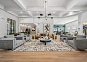 Thumbnail 15 of 21 - A spacious living room with grey couches and a patterned rug.