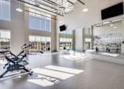 Thumbnail 26 of 34 - A gym with a treadmill, exercise bike, and other equipment.