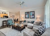 Thumbnail 5 of 37 - A living room with a white ceiling fan and a grey couch.