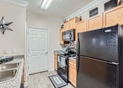 Thumbnail 11 of 37 - A black refrigerator is in a kitchen with a star decoration on the wall.