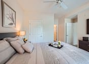 Thumbnail 15 of 37 - A bedroom with a large bed and a ceiling fan.