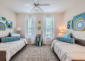 Thumbnail 17 of 37 - A bedroom with two beds and a ceiling fan.