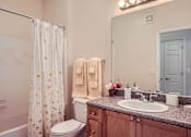 Thumbnail 21 of 37 - A bathroom with a toilet, sink, and shower curtain.