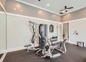 Thumbnail 35 of 37 - A home gym with a weight machine and a bench.