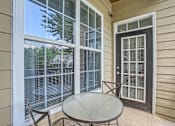 Thumbnail 25 of 37 - A patio with a table and chairs and a sliding glass door.