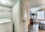 Thumbnail 8 of 16 - a room with a washer and dryer in it and a bedroom with a