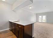 Thumbnail 3 of 37 - a kitchen with white countertops and dark wood cabinets