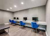 Thumbnail 23 of 62 - a room with three desks with computers and blue chairs