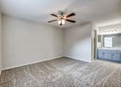 Thumbnail 22 of 62 - an empty bedroom with a ceiling fan and a bathroom