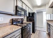 Thumbnail 18 of 62 - an apartment kitchen with black appliances and granite counter tops