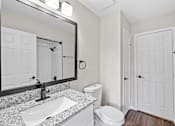 Thumbnail 49 of 54 - A bathroom with a granite countertop and white fixtures.
