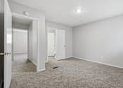 Thumbnail 6 of 23 - A room with white walls and carpeted floor with two doors.
