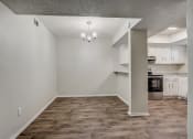 Thumbnail 4 of 26 - an empty living room with a kitchen in the background