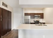Thumbnail 2 of 37 - a kitchen with white countertops and a stainless steel refrigerator