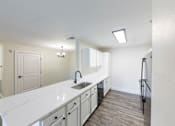 Thumbnail 18 of 40 - A kitchen with white countertops and a sink.