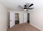 Thumbnail 10 of 40 - A room with a ceiling fan and two doors.