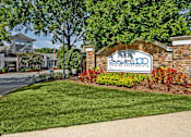 Thumbnail 24 of 25 - A sign for Premier Apartments is in front of a building.