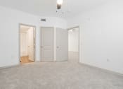 Thumbnail 25 of 41 - an empty living room with two doors and a carpeted floor