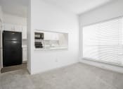 Thumbnail 14 of 33 - an empty room with a large window and a black refrigerator