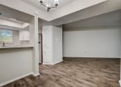 Thumbnail 7 of 36 - a kitchen and living room with hardwood floors and a chandelier