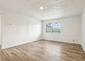 Thumbnail 8 of 21 - A room with wooden flooring and a window.