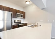 Thumbnail 1 of 37 - a kitchen with white countertops and wooden cabinets