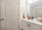 Thumbnail 18 of 35 - a bathroom with white cabinets and a sink and a mirror