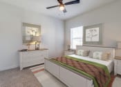 Thumbnail 13 of 65 - a bedroom with a bed and a ceiling fan