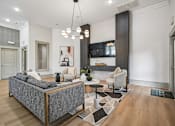 Thumbnail 16 of 21 - A modern living room with a grey sofa and a black and white rug.